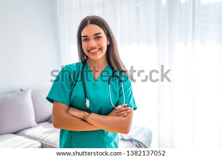 Portrait of young attractive smiling nurse. Hoome nurse. Caucasian woman working in nursing home. Beautiful young nurse woman wearing uniform and stethoscope