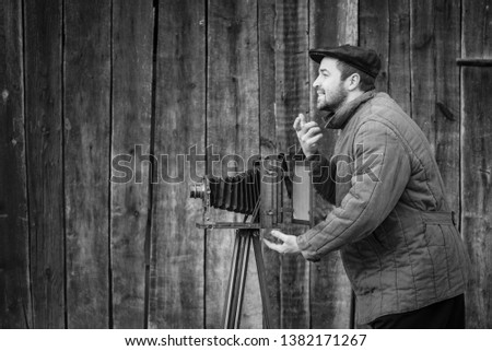 Old fashioned photographer asks for a smile. Works on large format camera. Concept - photography of the 1930s-1950s