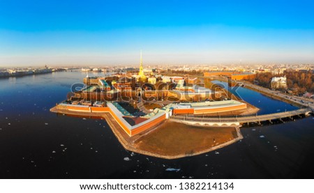Beautifull aerial view of the Petropavlovsky fortress in sunny spring day. Golden tall spire of famous Peter and Paul Cathedral on the blue sky background. Historical centre of St. Petersburg, Russia.