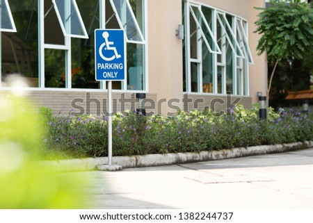 Parking space reserved for Reserved shoppers in a retail parking lot . Parking for disabled or wheelchair . A sign indicates reserved parking for disabled people in a car park. 