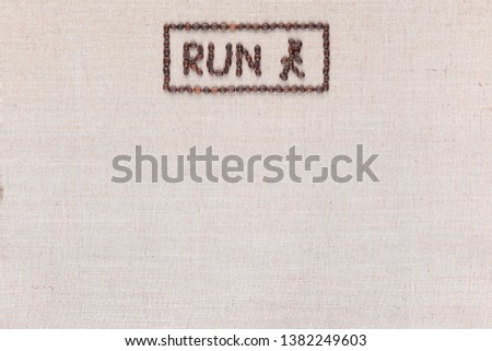Running sign enclosed in a rectangle made from roasted coffee beans shot on linea canvas aligned top center.