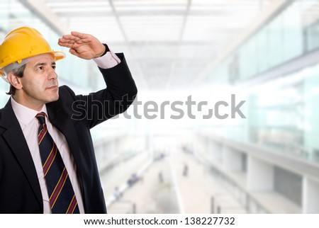 An engineer with yellow hardhat at the office
