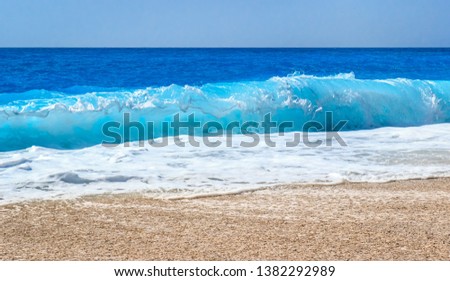Close up photo of beautiful sea wave splash with foam on a sandy beach. Summer vibes. Vacation holiday scenery in Lefkada, Greece