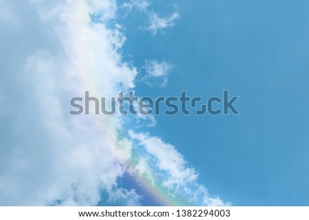Piece of picturesque multicolored rainbow on the romantic sky. Clear afternoon day with white clouds. Background and wallpaper designer. cerulean, sky blue, blue light, bluish, royal blue