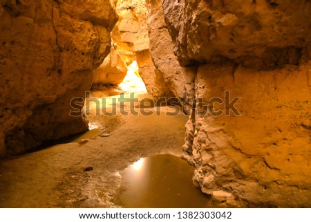 A sunlit water pool at the narrow passage of Sesriem Canyon. A natural gorge carved by the powerful Tsauchab River millions of years ago.