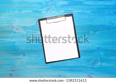 Blank document page on blue wooden table background.