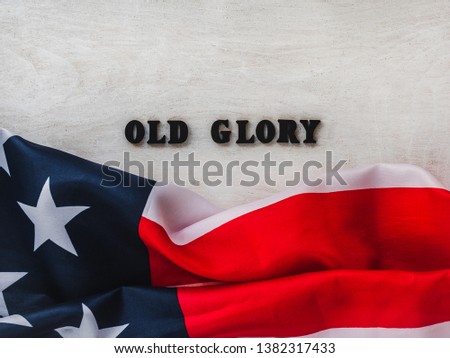 Happy American Flag Day. Wooden letters with a congratulatory inscription on the background of wooden boards. Close-up, top view. Preparation for the holiday. Congratulations for friends, colleagues