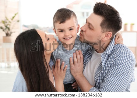 Happy parents kissing their son at home. Family time
