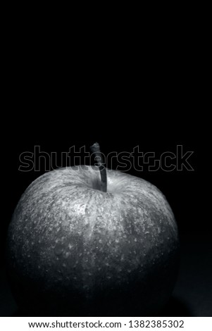 apple with drops of water on black background, image conveys freshness, black and white photography and free space above for text