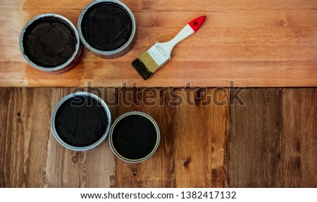 Top view on a newly opened can of wax, varnish, oil, paint on a freshly painted wooden surface. Several wood coating options, artwork, texture or background for text