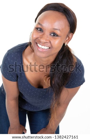 Dark-skinned woman dressed casually smiling joyfully showing her white straight teeth 
