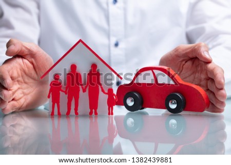 Photo Of Businessman Protecting Family Figure, House Model And Car
