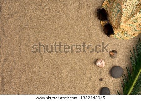 Frame of straw hat, sunglasses, seashells. Traveler accessories on sand. Travel vacation concept. Summer background