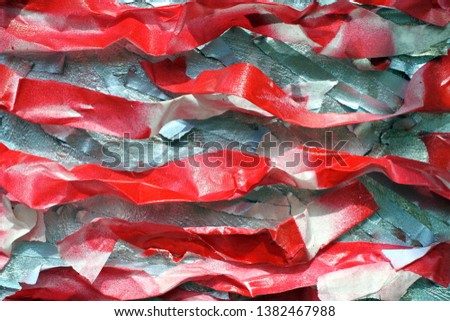 bright red crumpled strips of ribbon. pieces of cut colored paper. the adhesive tape is painted in several layers. background of complex color texture. 

