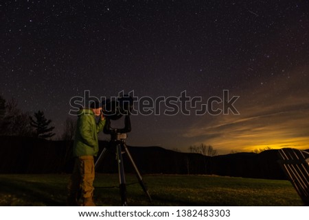 Man looking at stars at night with a telescope