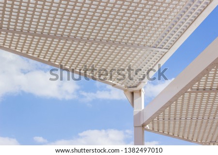 white iron roof construction cover from the sun in restaurant patio penthouse, exterior design concept, soft blue sky with clouds background 