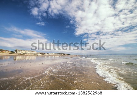 Sea waves washing onto scenic beach at bright summer day. Tywyn in Mid Wales, United Kingdom