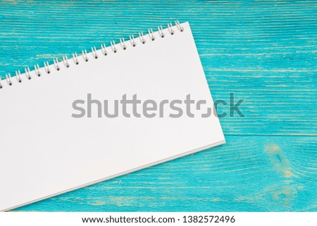 blank notepad over turquoise wooden table