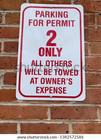 Parking for Permit 2 Only, All Others Will Be Towed at Owner's Expense sign on brick wall