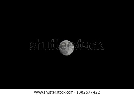 Bright white full moon contrasted with a black night sky