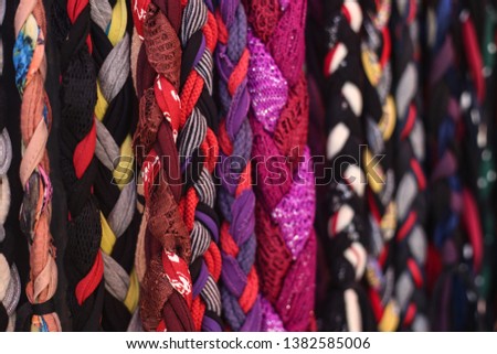 Colorful patterned rope belts hanging 