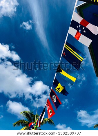 Latin American flags in the blue sky with clouds
