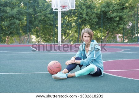 A woman in sports clothes looks straight at the camera. A woman after a morning workout on the playground.