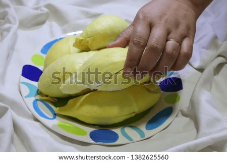 Close-up pictures of the hands of people picking durian in popular fruit dishes
