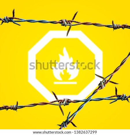 Creative fire caution sign decorated with barbed wire on yellow background.