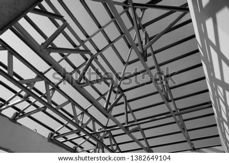 Structure of steel roof frame for building construction. Black and white photo.
