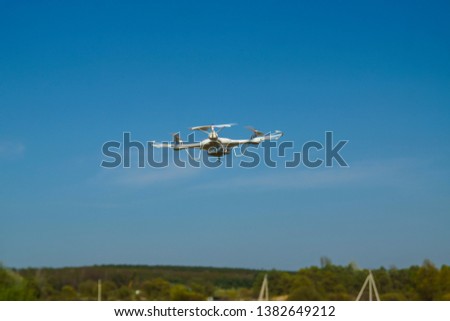  white quadcopter with camera for photo and video shooting flying in the sky                              