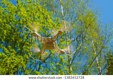  white quadcopter with camera for photo and video shooting flight in a birch grove                              