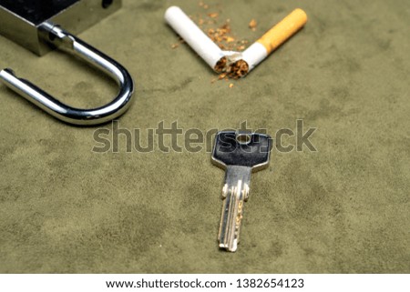 Exemption from smoking. The key on the background of a broken cigarette and an open lock.