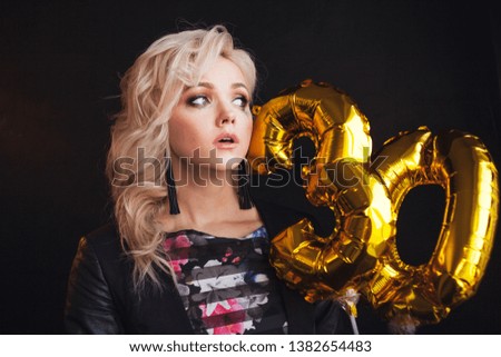 young beautiful woman is sad on her birthday. Charming blonde crying because of age. black background