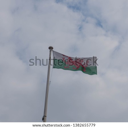 The Flag of Wales with a Cloudy Sky Background at Mermaid Quay on the Waterfront in Cardiff Bay, Wales, UK