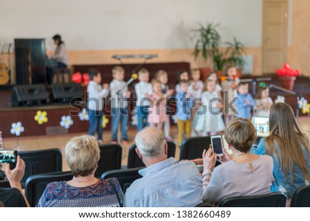 Performance by talented children. Children on stage perform in front of parents. image of blur kid 's show on stage at school , for background usage. Blurry