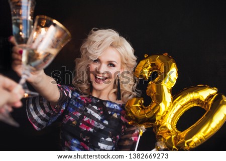 Holiday party, a beautiful young blonde woman drinking champagne. Birthday party, joy and fun.