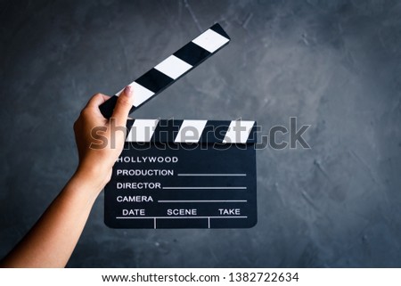 Women hands holding clapper board for making video cinema in studio.