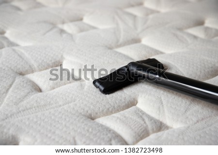 cleaning mattress by vacuum cleaner. dust mites on bed, texture. concept : allergy in bed room. Royalty-Free Stock Photo #1382723498