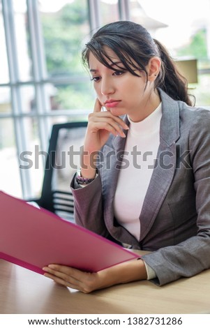 Young Asian woman stress with her business online shopping at office. Boring business office life concept.