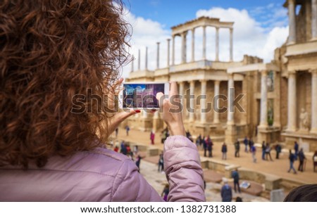 Tourist girl taking a picture with the smartphone in the antique Roman Theatre of Merida. The Archaeological Ensemble of Merida is declared a UNESCO World Heritage Site Ref 664