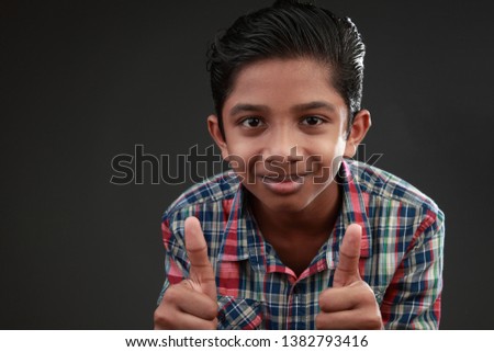 Portrait of smiling boy shows thumbs up sign