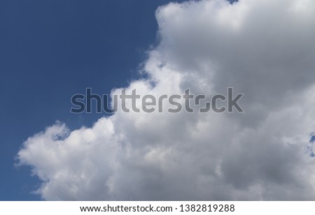 Beautiful fluffy white clouds covered in sunlight on a deep blue sky 