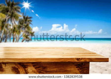 Table background of free space for your decoration. Summer landscape of beach with palms and summer sun. 