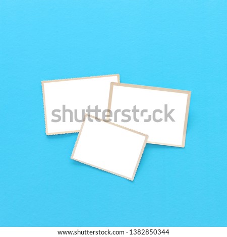 top view of blank photo frames over blue background. Top view flat lay