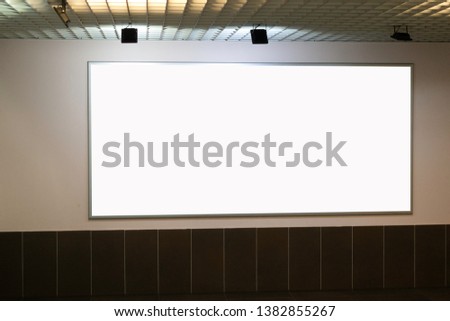 Mock up. Big horizontal blank white billboard on the wall inside building
