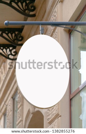 Mock up. Blank oval shape signboard on the wall of classical architecture building