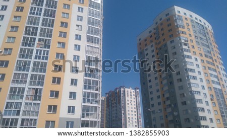 White and yellow modern skyscrapers apartment houses under blue sky