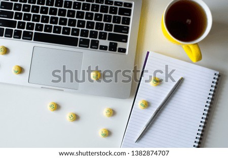 Yellow candy in the form of an emoticon on a buisness background. Medicine tablets or pills. Funny faces on the white background.