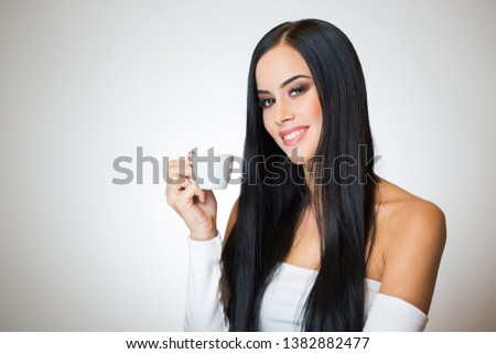 Gorgeous young brunette woman holding cup of espresso.